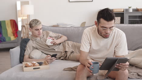 couple sitting sofa at home and having bite
