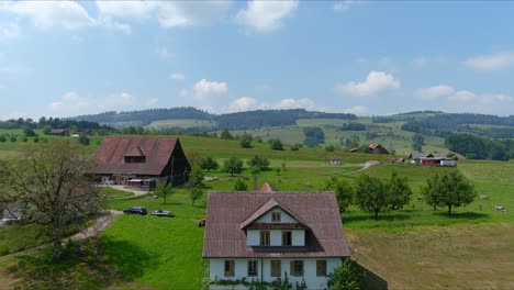 Paso-Elevado-De-Kussnacht:-Moviéndose-Sobre-Un-Pintoresco-Valle-De-Agua-Y-Un-Pueblo-En-Las-Montañas-De-Los-Alpes,-Suiza,-Europa,-Drone-|-Primer-Plano-Dramático-Reverso-Cinematográfico-De-Una-Pequeña-Casa-En-Un-Vasto-Campo