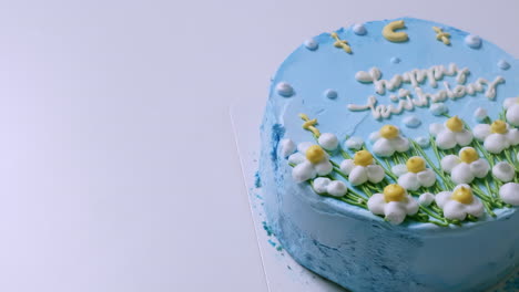 Panning-from-right-to-the-left-side-of-the-frame-on-a-spongy-and-creamy,-blue-birthday-cake