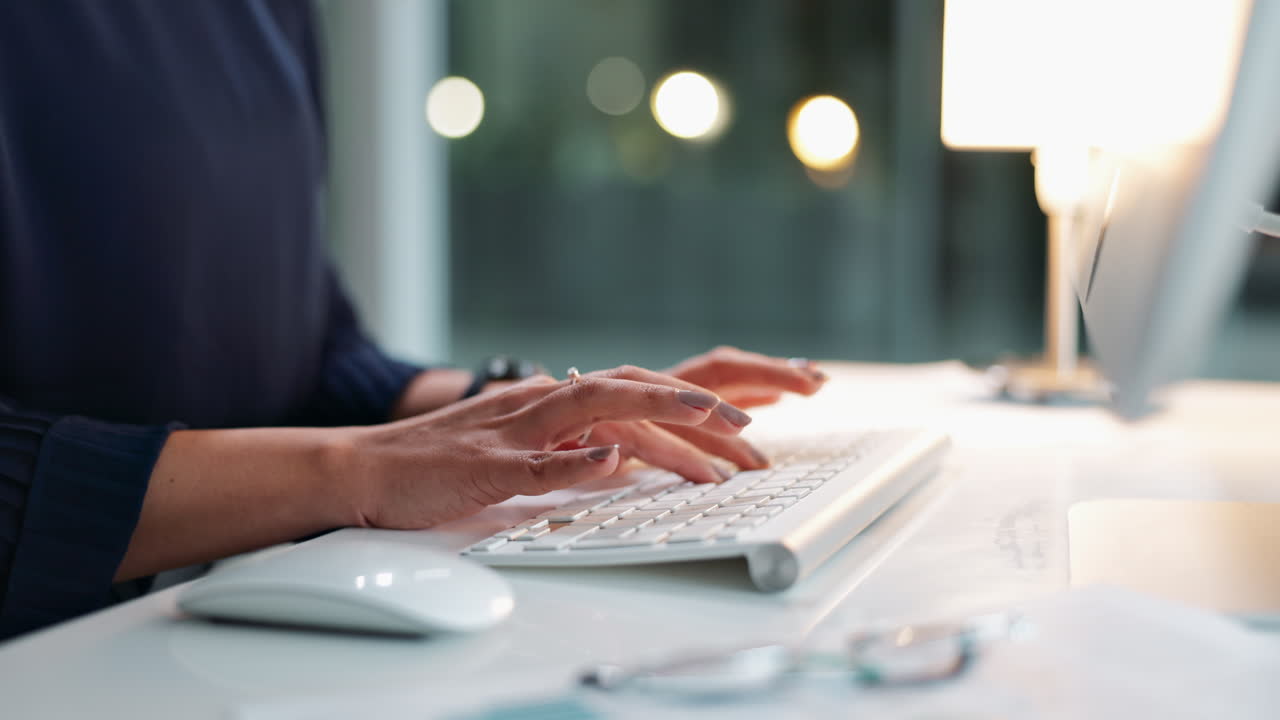 Hands typing on a computer keyboard