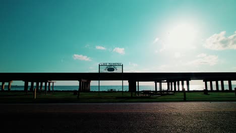 golden hour view of lake maurepas underpass bridge with grassy park and calm lake, perfect road trip scenery.