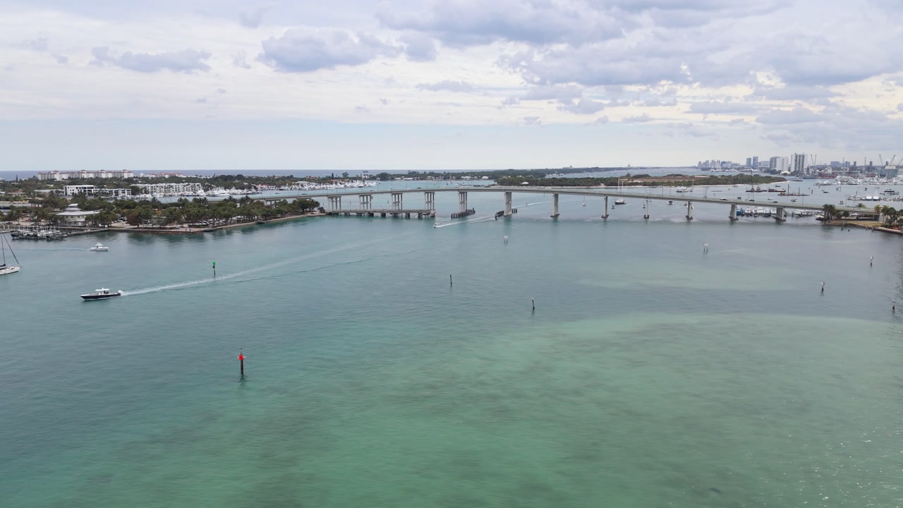 Slow right to left pan facing the Blue Heron Bridge showing high-rises, Phil Foster Park and boats on the Intracoastal Waterway near Singer Island and Riviera Beach Florida in Palm Beach County.