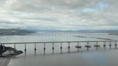 Una-Vista-Aérea-Del-Puente-Tay-Road-Con-El-Puente-Ferroviario-Al-Fondo-En-Un-Día-Nublado