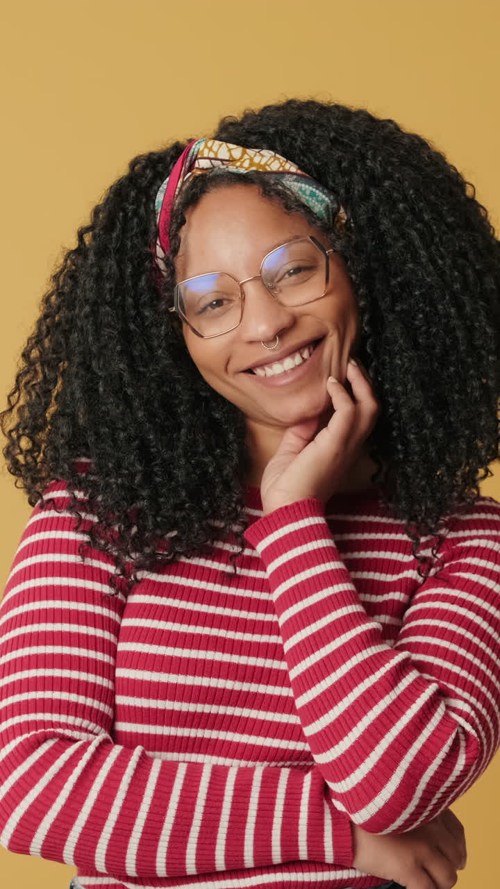 Happy Young Woman with Curly Hair Smiling in Studio