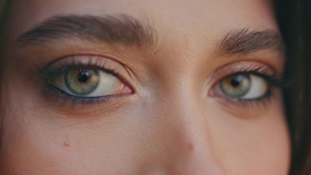Macro close-up de maquiagem nos olhos verdes de mulher. Olhar feminino piscando, olhando para a câmera.