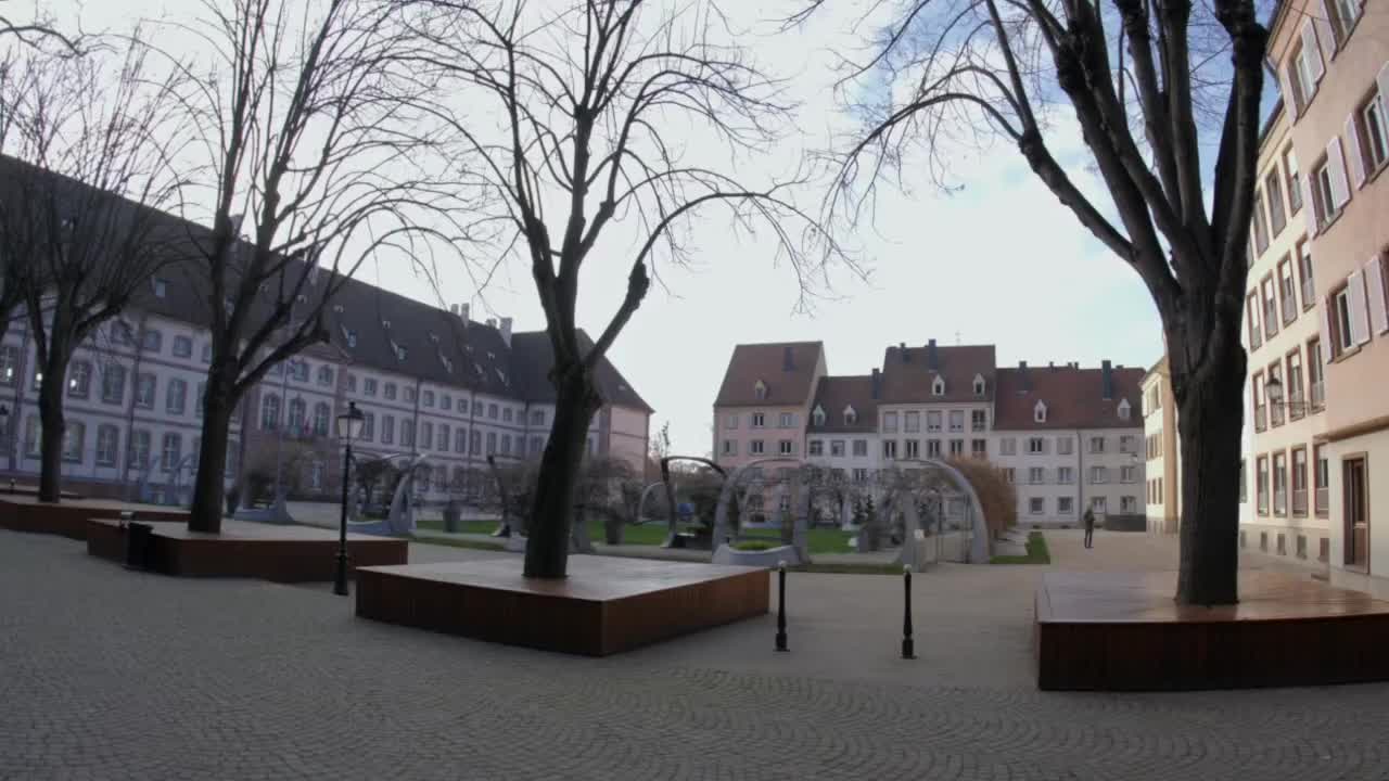 Design urbano contemporaneo nella storica Colmar. Caratterizzata da grandi fioriere in legno, un'ampia piazza in pietra ed edifici tradizionali alsaziani sotto un cielo invernale luminoso