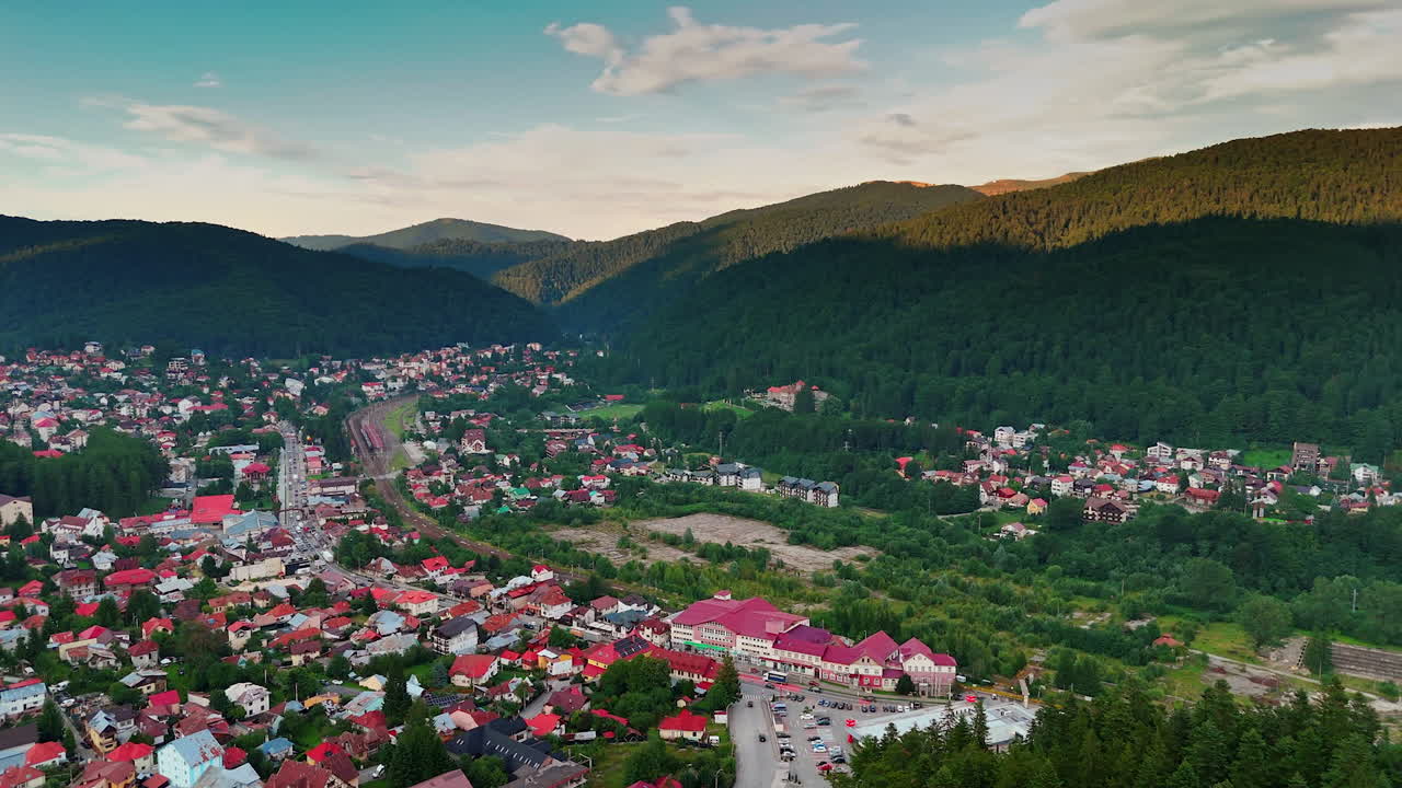 Filmato aereo della confortevole zona residenziale tra le verdi montagne. La vivace città di Busteni, in Romania, vista da un drone
