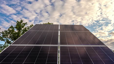 lapso de tiempo de los paneles solares que recogen energía limpia con el telón de fondo de un paisaje nuboso diurno