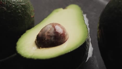 Micro-video-of-close-up-of-avocados-with-copy-space-on-grey-background