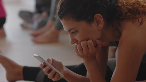 clase de yoga mujer hermosa usando tecnología de teléfono inteligente descansando después del entrenamiento enviando mensajes de texto compartiendo estilo de vida de fitness en las redes sociales relajándose en el estudio