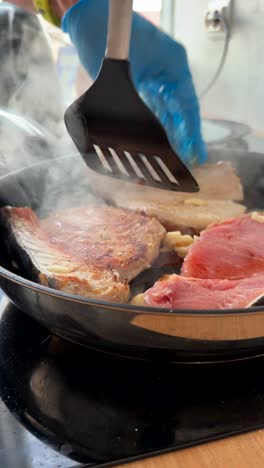 cooking pork chops and garlic in a frying pan