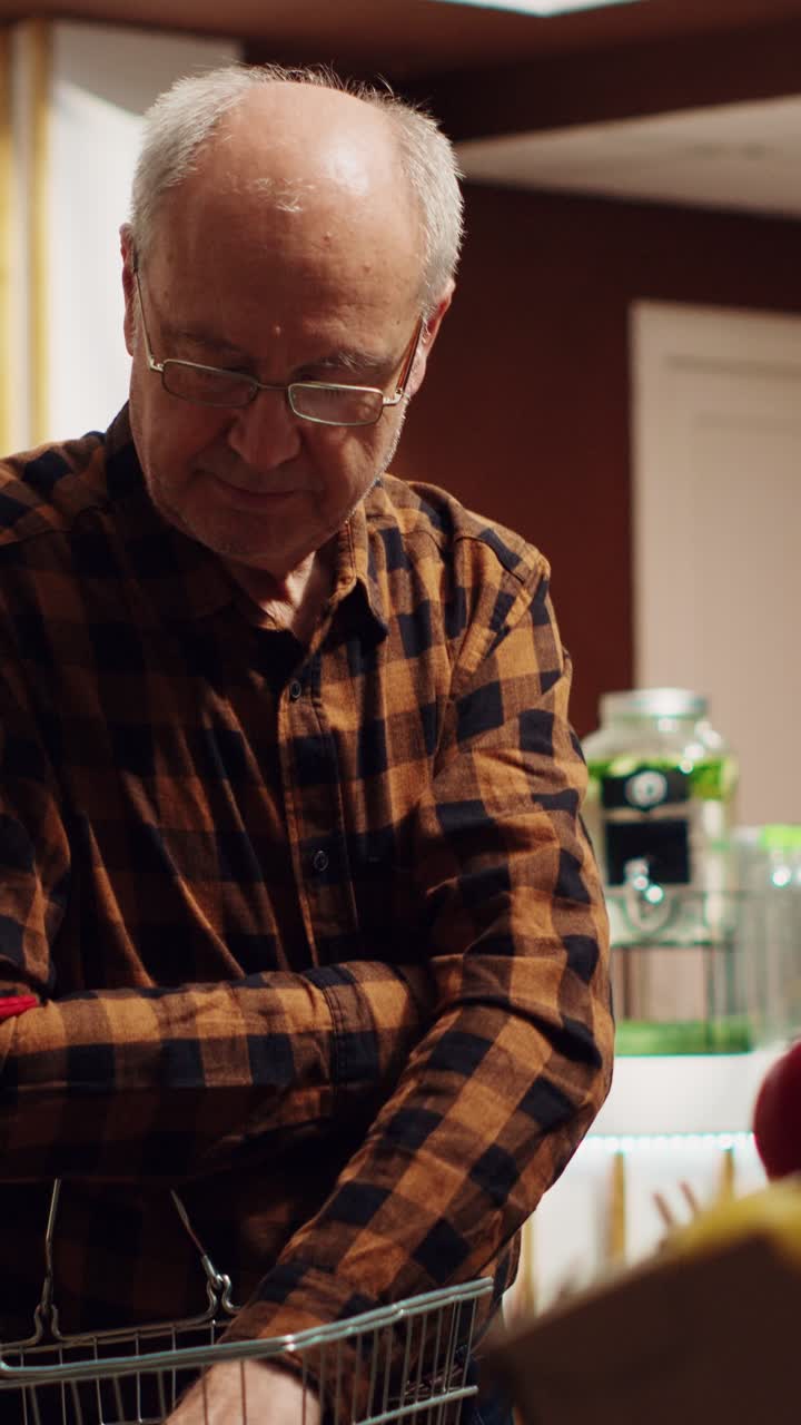 Pionowy film: Starszy mężczyzna kupuje jedzenie w słoikach wielokrotnego użytku