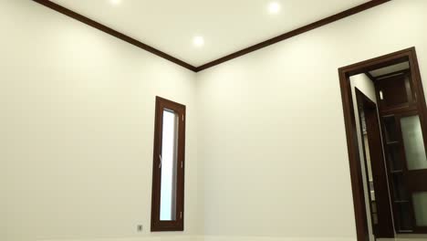 empty room with white walls and brown wood trim with marble floor