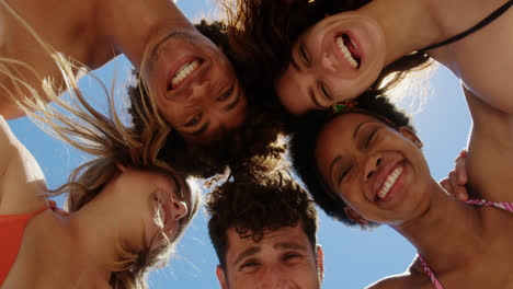 Young-friends-forming-huddle-at-beach-4k