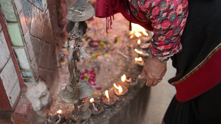 People Praying in Bhaktapur in Nepal, Person in Bhaktapur Ancient City in Prayer with Candles at a Temple, a Sacred and Holy Place in Nepal, and Popular Famous Tourist Destination