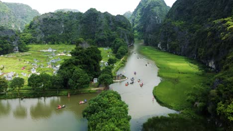 flying over a river in ninh binh, capturing small boat tours passing by an ancient cemetery