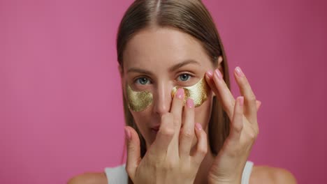 woman applying gold eye patches