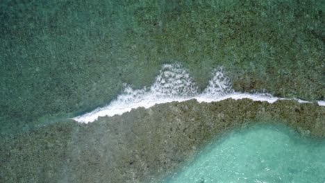 Lagune-In-Samoa---Meeresboden-Durch-Das-Kristallklare-Meerwasser-Gesehen,-Wellen-Plätschern-In-Zeitlupe---Luftaufnahme