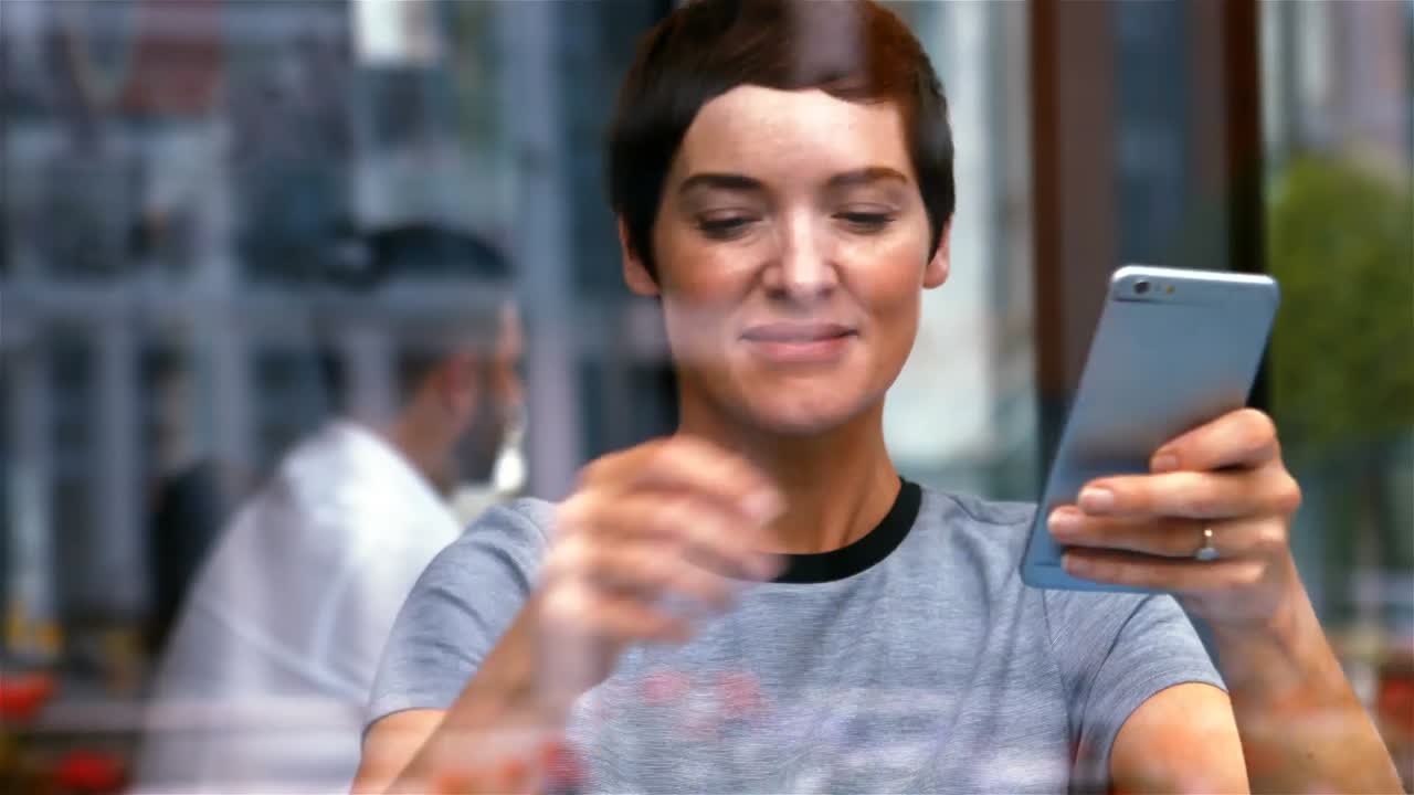 mujer de negocios usando el teléfono móvil mientras toma café