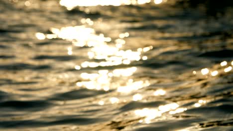 at sunset, the sun's rays are reflected on the surface of the water, close up