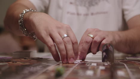 hand turning cards of board game, closeup view of hands and fingers