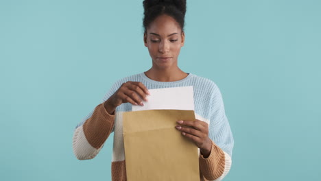 excited woman opening envelope and reading papers