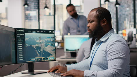 Employee Using Electric Grid With Wind Farm Layout Modeling Software