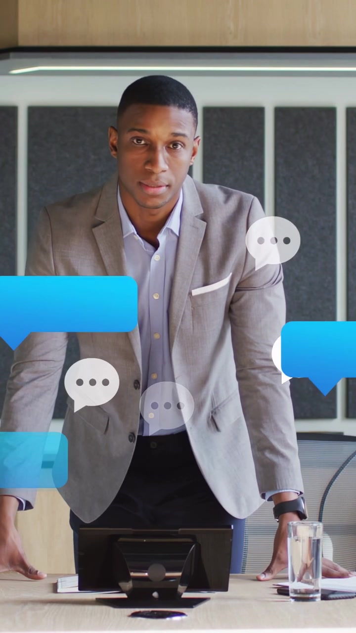 Vertical video: Man leaning forward in office meeting, pings forming chat bubbles, responding