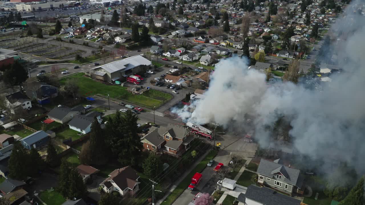 거리에서 소방차와 함께 불타고 있는 집에서 두꺼운 연기가 상승하고 있습니다.