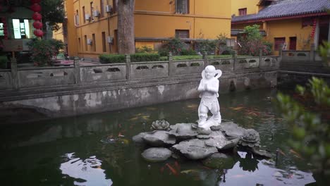 buddhist temple statue in fish pond slow motion