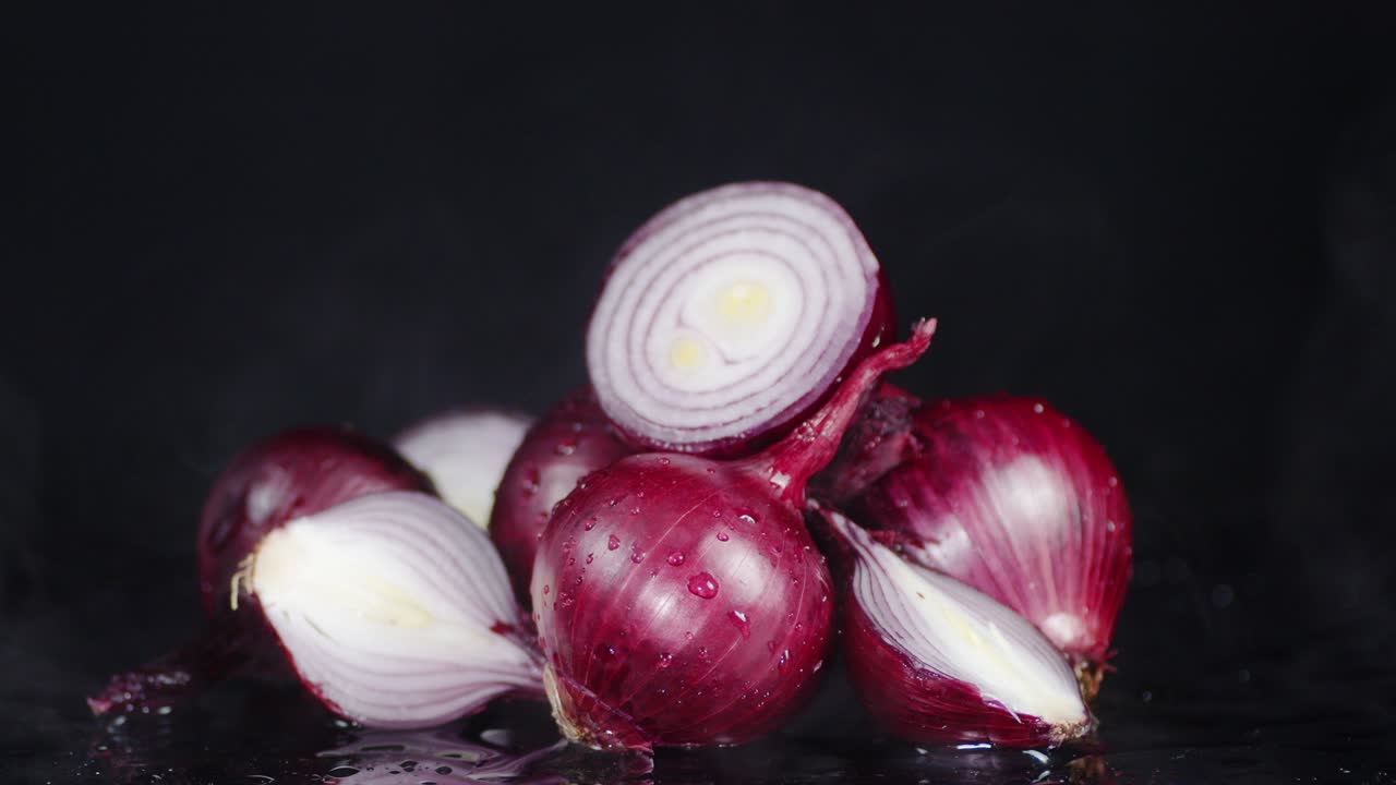 A whole and halved red onion with cool steam.