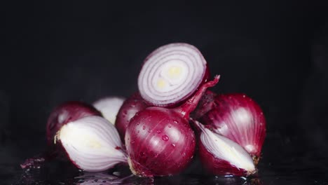 una cebolla roja entera y cortada a la mitad con vapor frío.