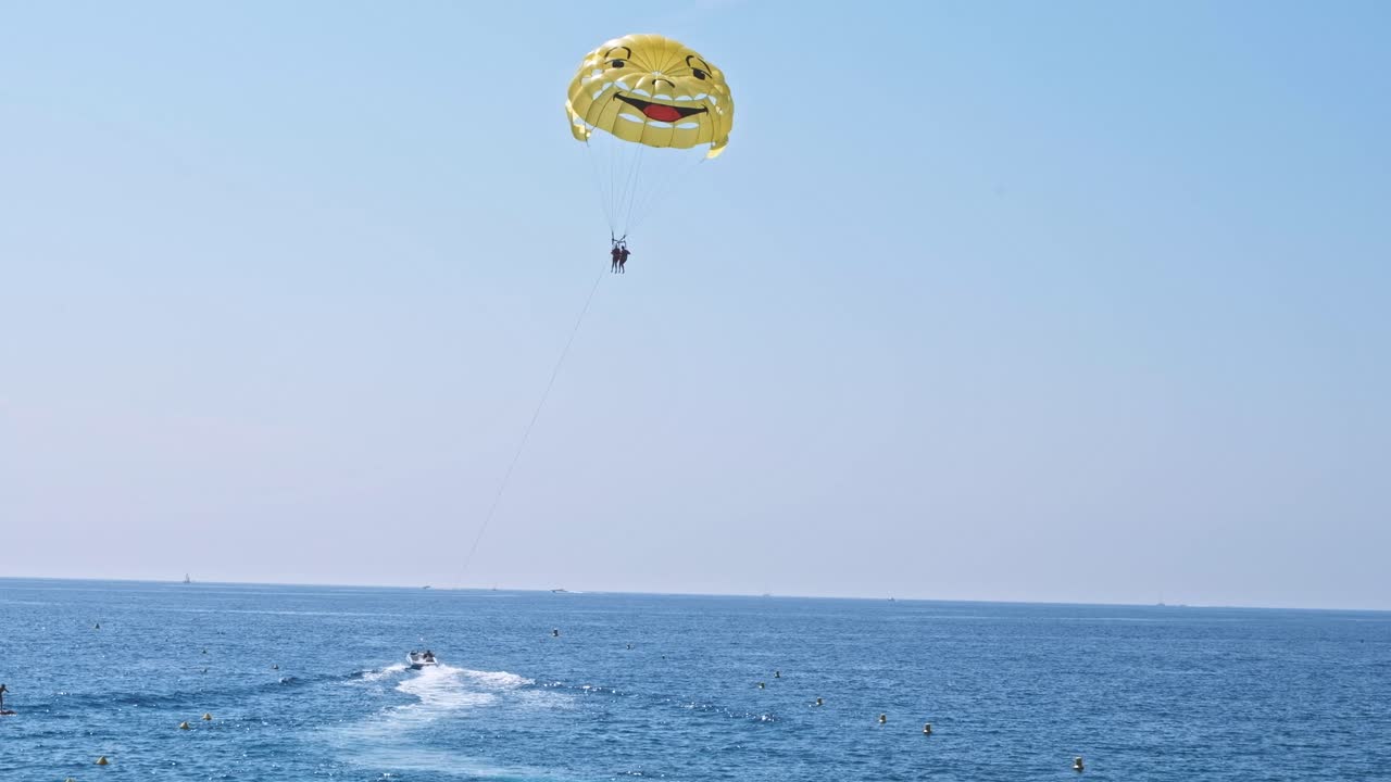 Scenic view of people enjoying watersports and parachute on the beach in Nice, France