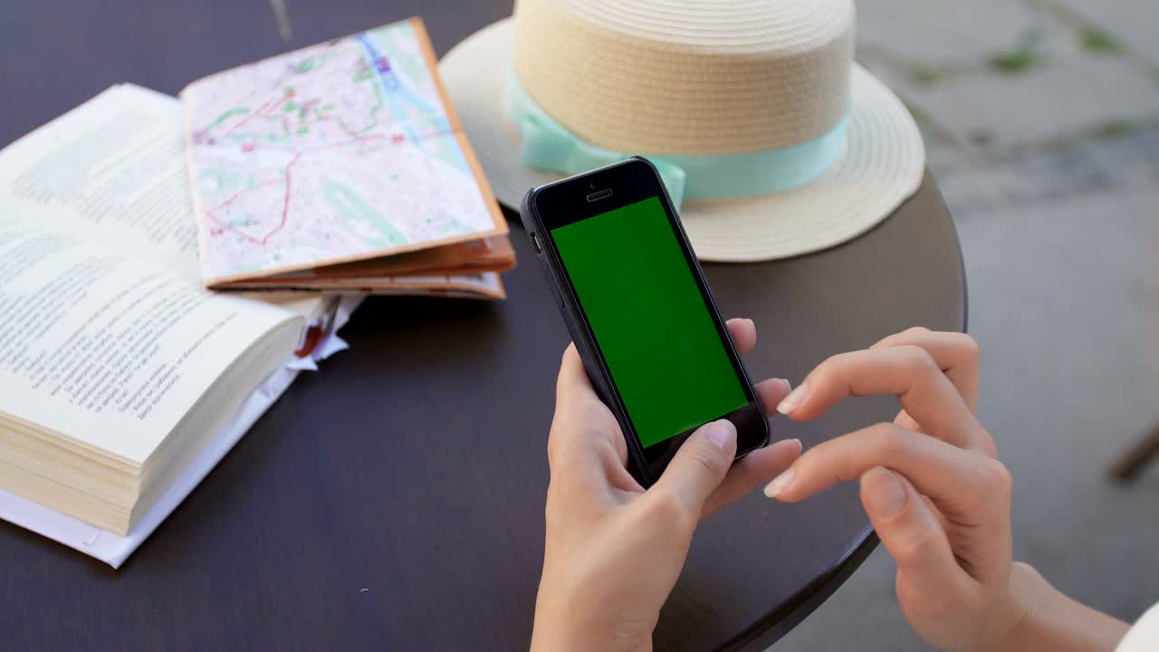 mujer usando un teléfono inteligente en una cafetería. teléfono inteligente con pantalla verde
