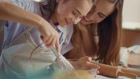 madre e hija mezclando huevos