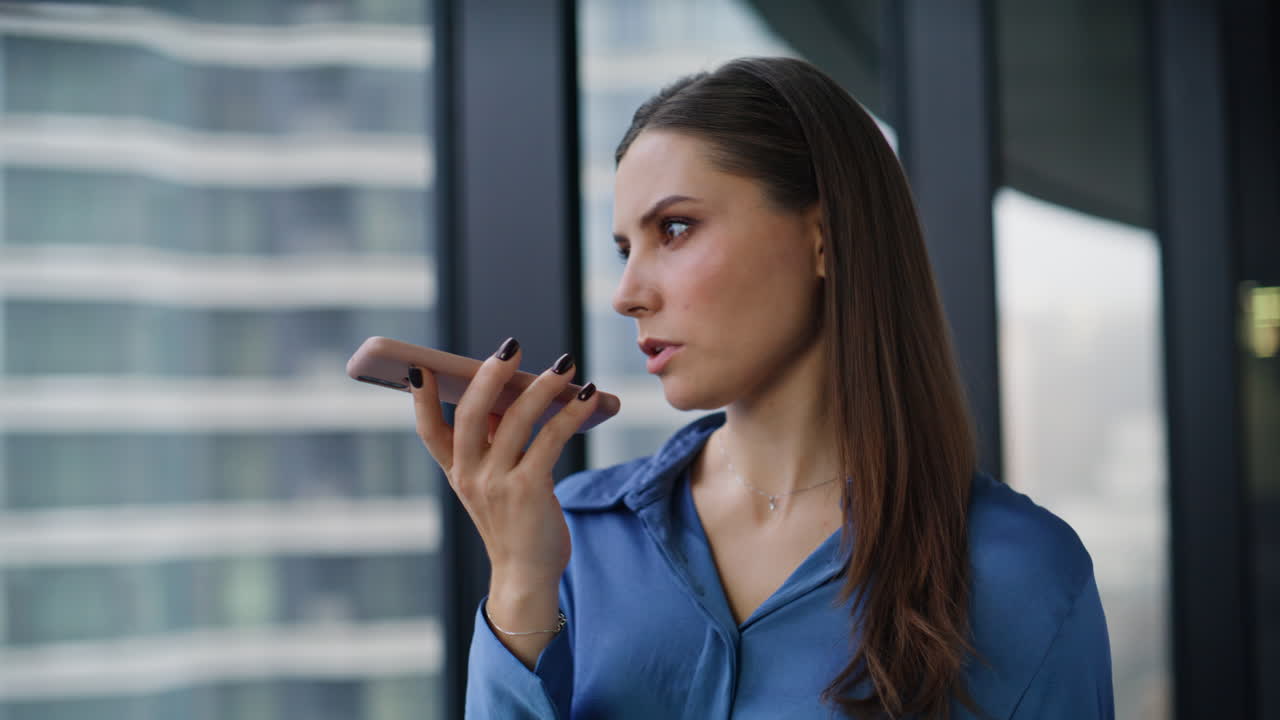 Employee recording audio message talking cellphone loudspeaker in office closeup