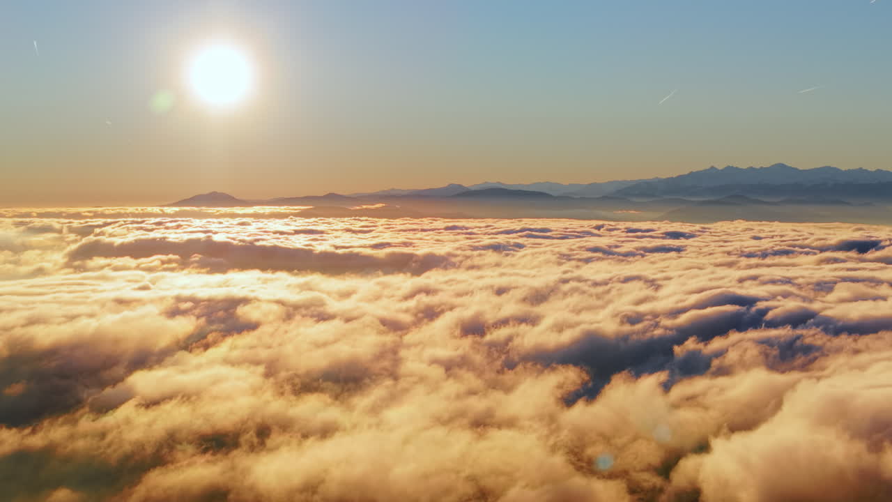 Alba aerea sopra montagne alpine innevate e nuvole, drone sereno all'alba