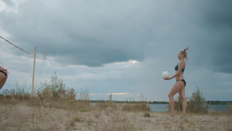 hermosas damas vestidas con bikini deportivo están jugando voleibol de playa en las vacaciones de verano mujeres atléticas están saltando