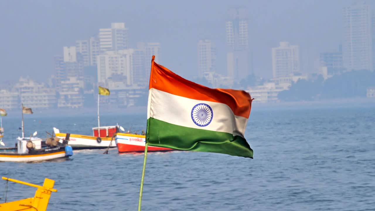 Indian national flag waving in a sea against city skyline