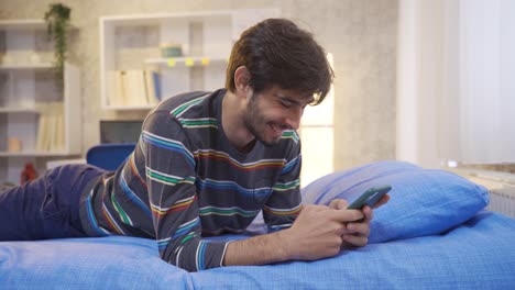 Joven-Enviando-Mensajes-De-Texto-Por-Teléfono-En-Su-Habitación.