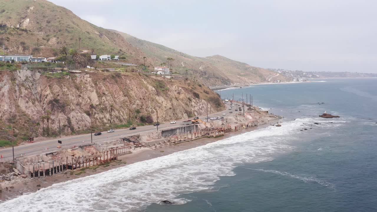 Aerial rising panning shot of burned beachfront homes along the Pacific Coast Highway after the Palisades Fire in Malibu, California. 4K