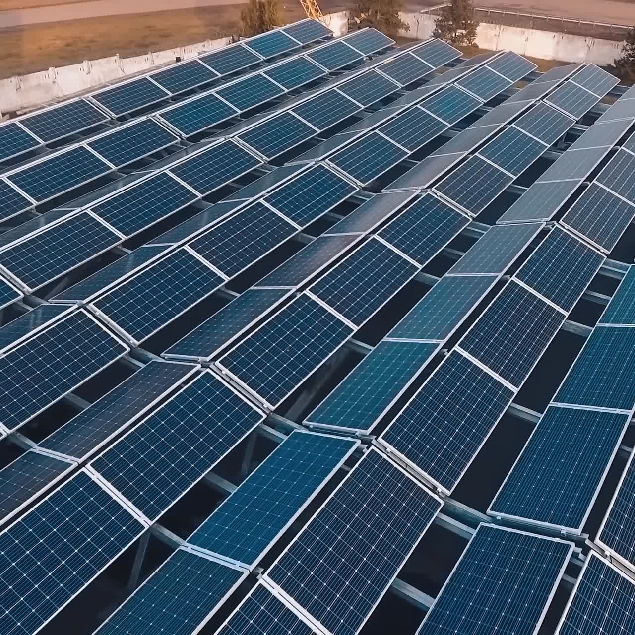 Innovative solar farm on roof. Solar panels on a roof of a building on nature background. Renewable green alternative energy concept.