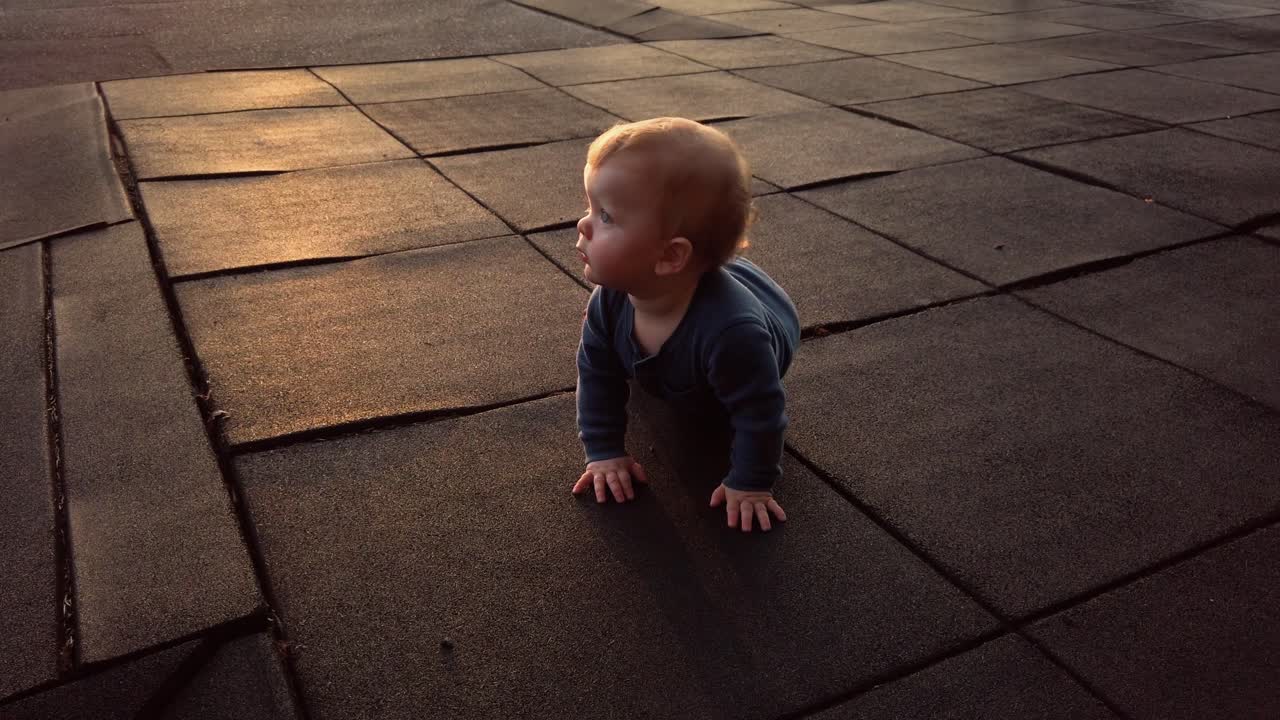 un niño pequeño feliz se sienta frente a la puesta de sol y se acuesta en una alfombra de goma en las cálidas noches de verano