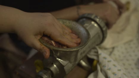 aplastando la carne dentro del malo mientras se hacen salchichas, tradición italiana