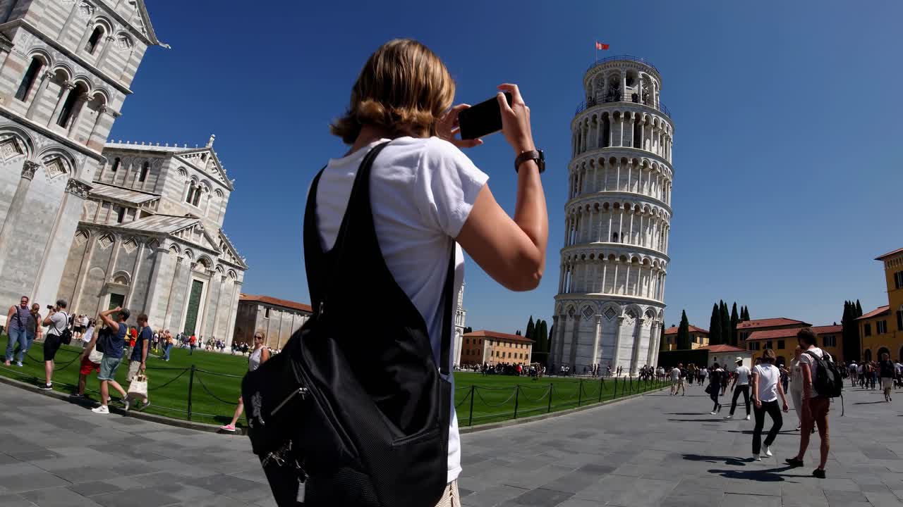 Pisa Kulesi ve çevredeki binaların açık mavi gökyüzü altında geniş açılı çekimi