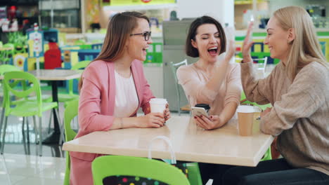 women friends enjoying coffee and conversation in a food court