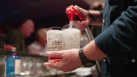 4K-Slow-Motion-Bartender-Pouring-Soft-Drink-From-Dispenser-Into-Glasses-At-Busy-Bar