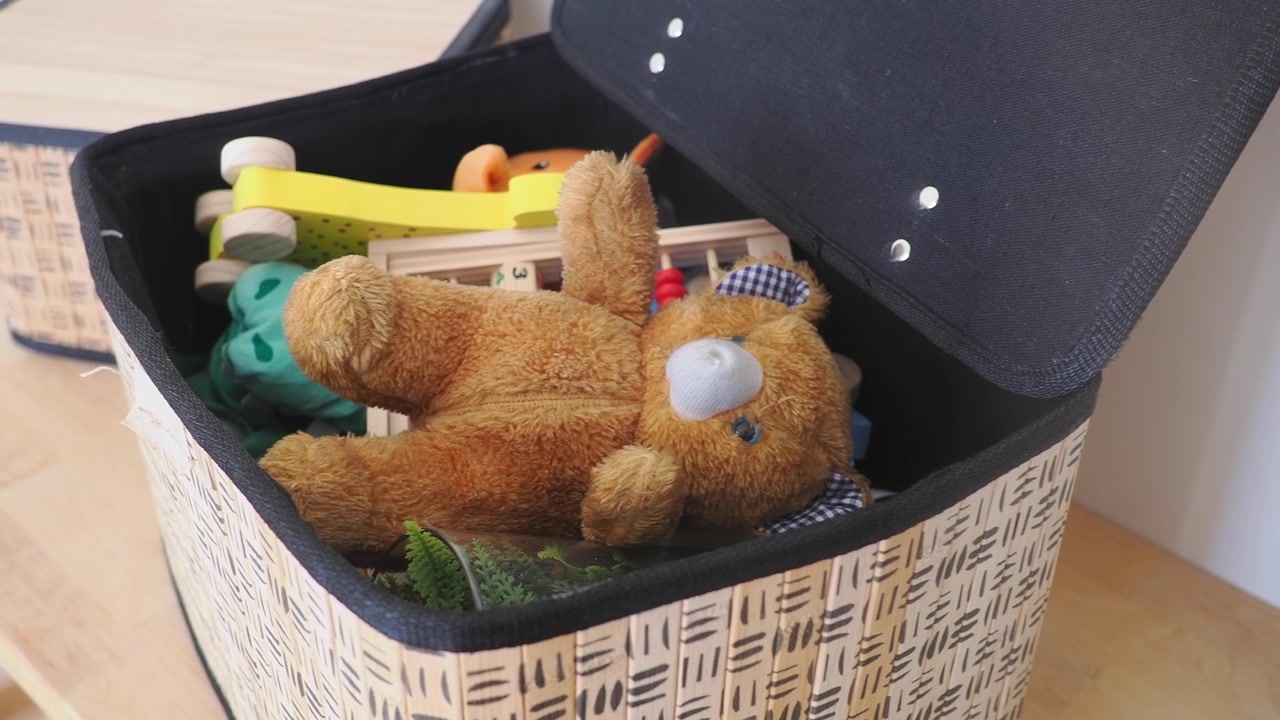 Orsetto di peluche marrone e giocattoli di legno in una scatola portaoggetti