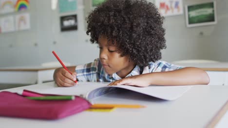 video of focused african american boy doing lessons in classroom