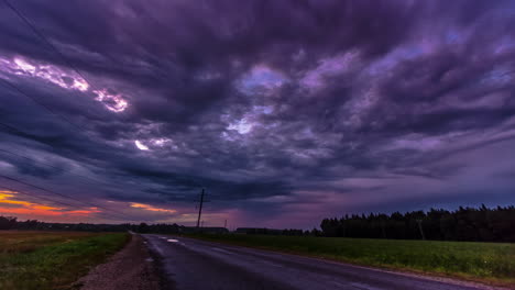 Vehicles-Traveling-On-Remote-Road-Under-Clouded-Sky-During-Sunset